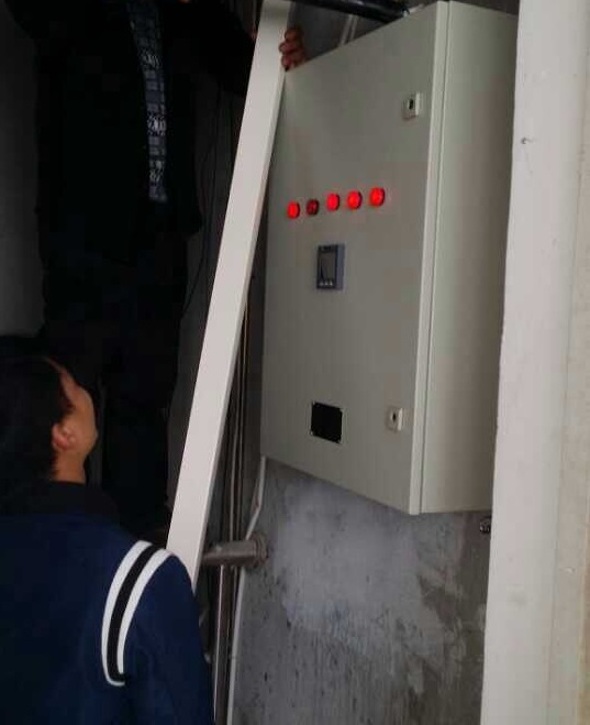 图为工作人员正在检查供电箱