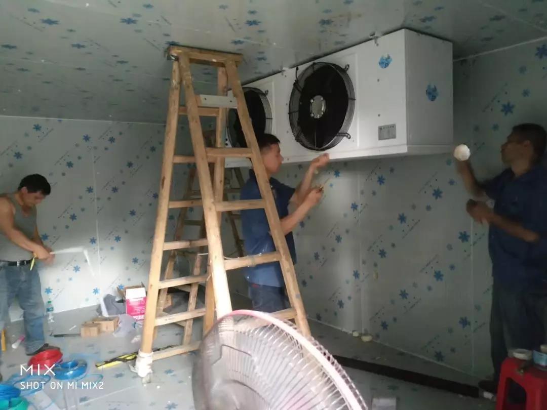 图为安装工人正在安装冷风机
