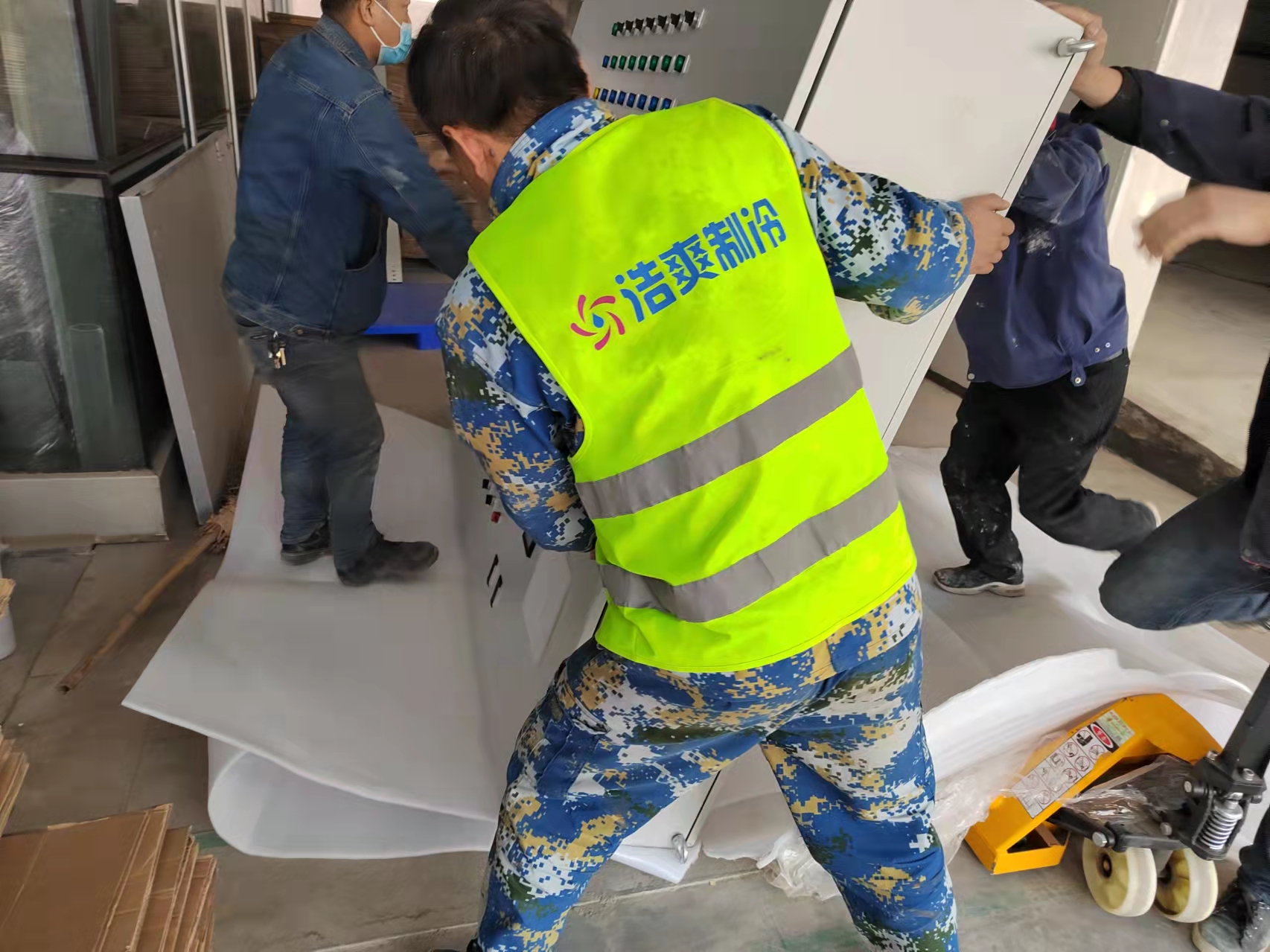 图为浩爽工人正在搬运电控设备