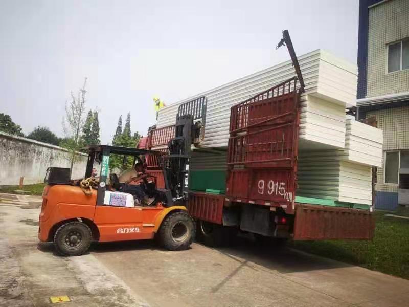 图为工人正在卸库板